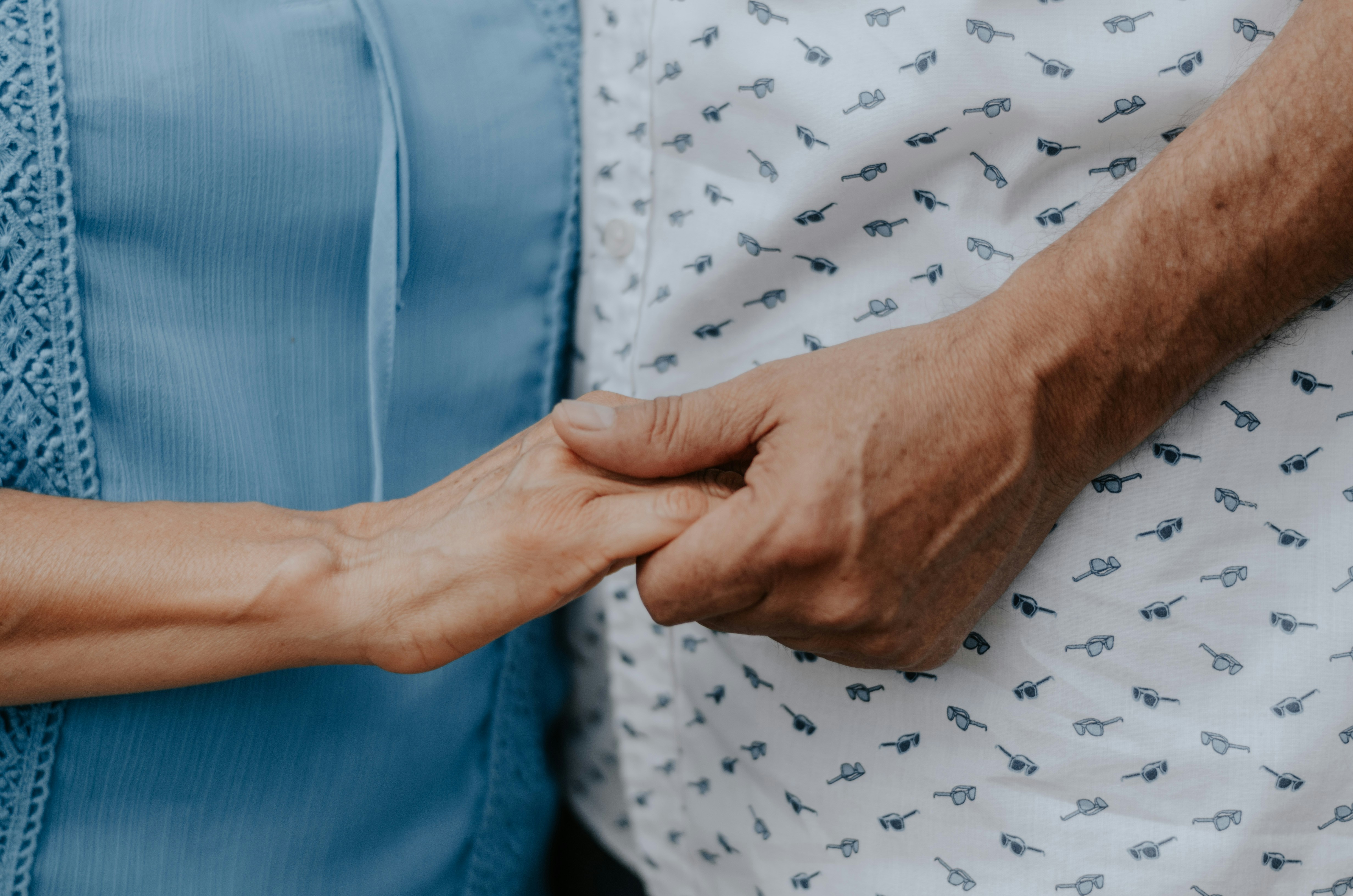 Patient and caregiver holding hands